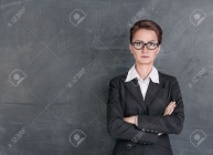 20897485-Strict-teacher-on-the-school-blackboard-background-Stock-Photo.jpg
